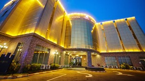 A hotel with a modern design, featuring a prominent entrance and a curved facade. - Corinthia Villa Hotel (Abuja)