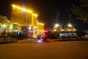 Vista frontal de la propiedad por la tarde o noche