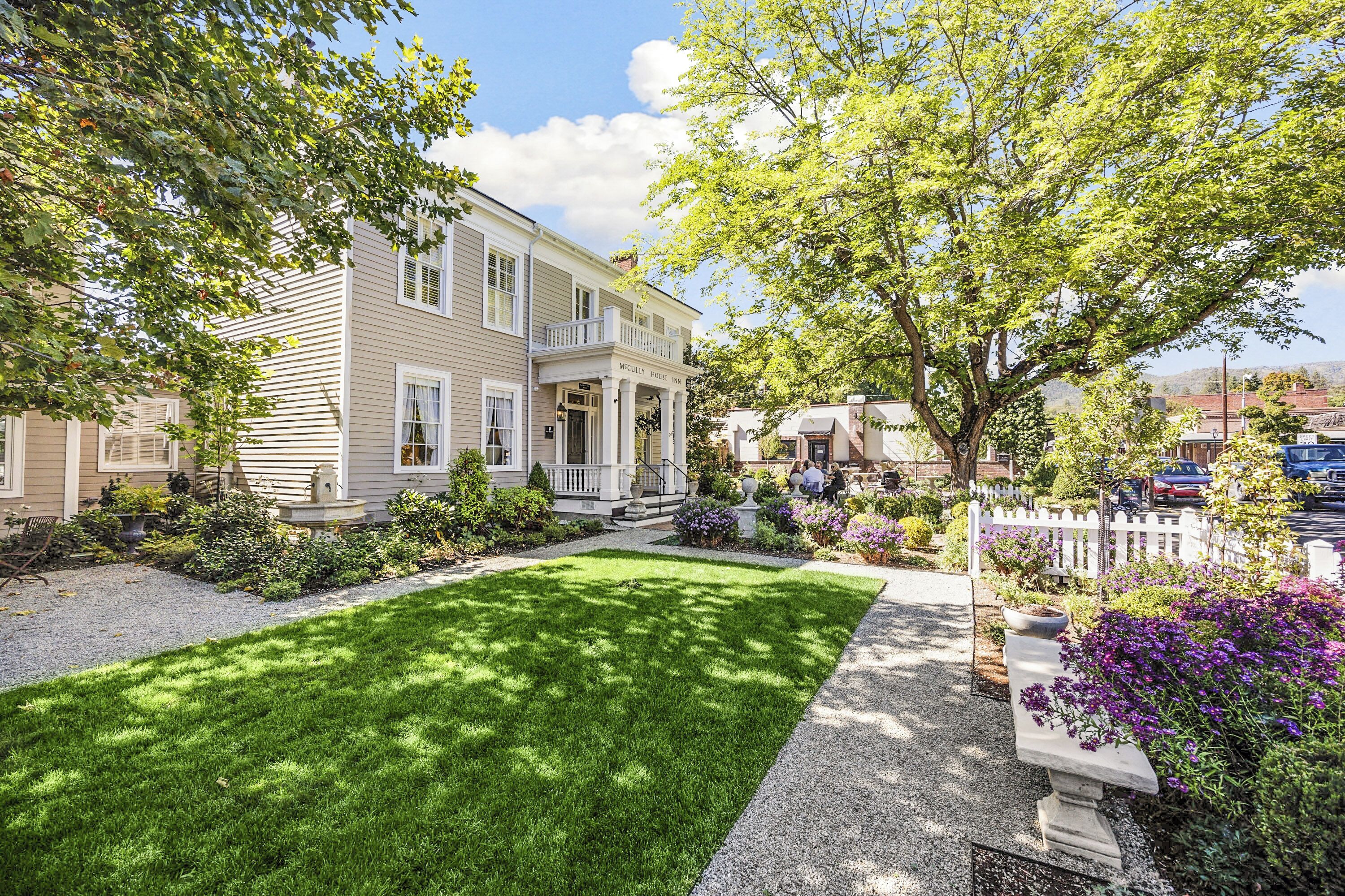 A two-story house with a front porch and a well-maintained lawn.