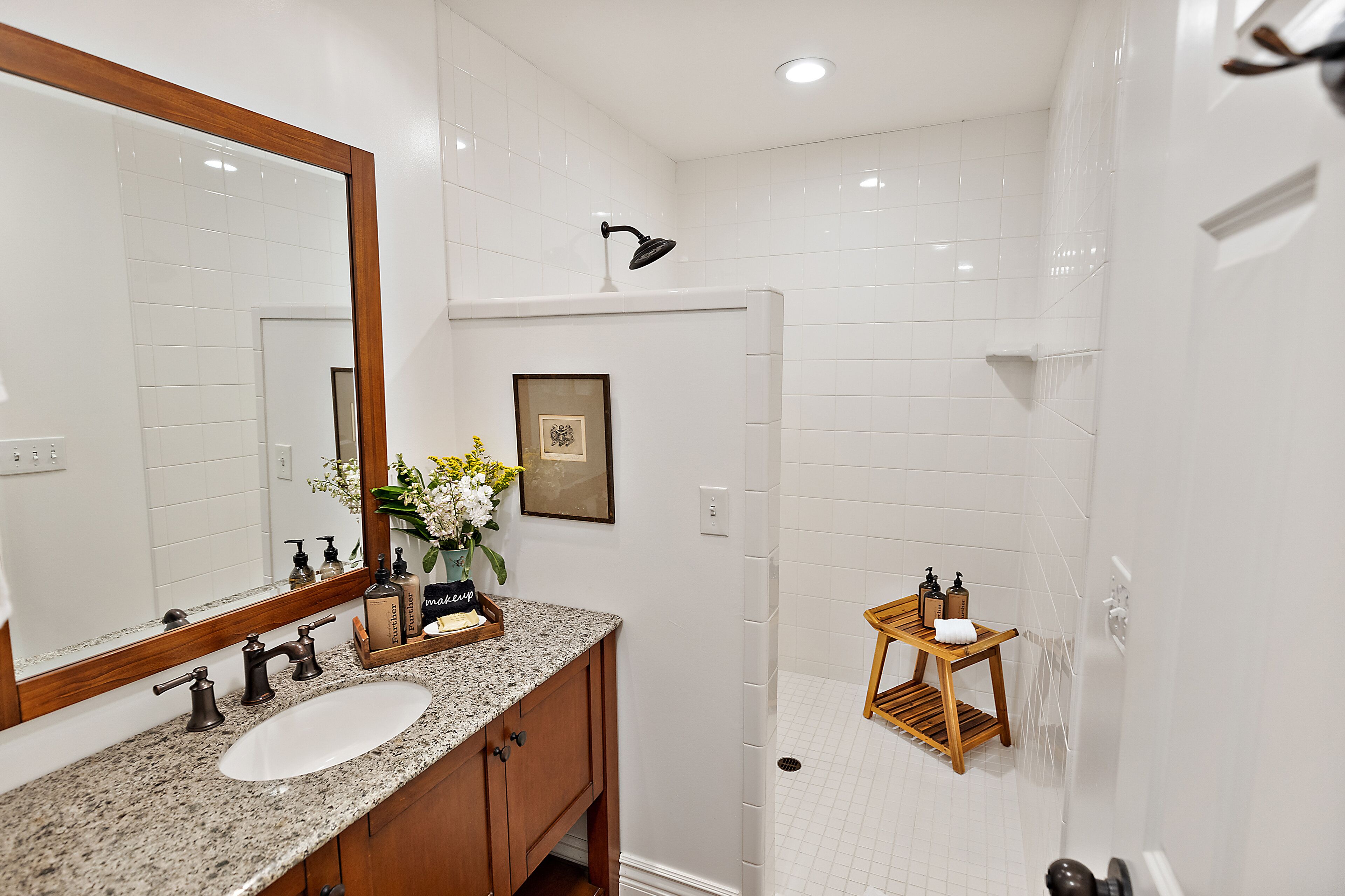 Une salle de bain équipée d’un lavabo, d’un miroir et d’un espace douche.