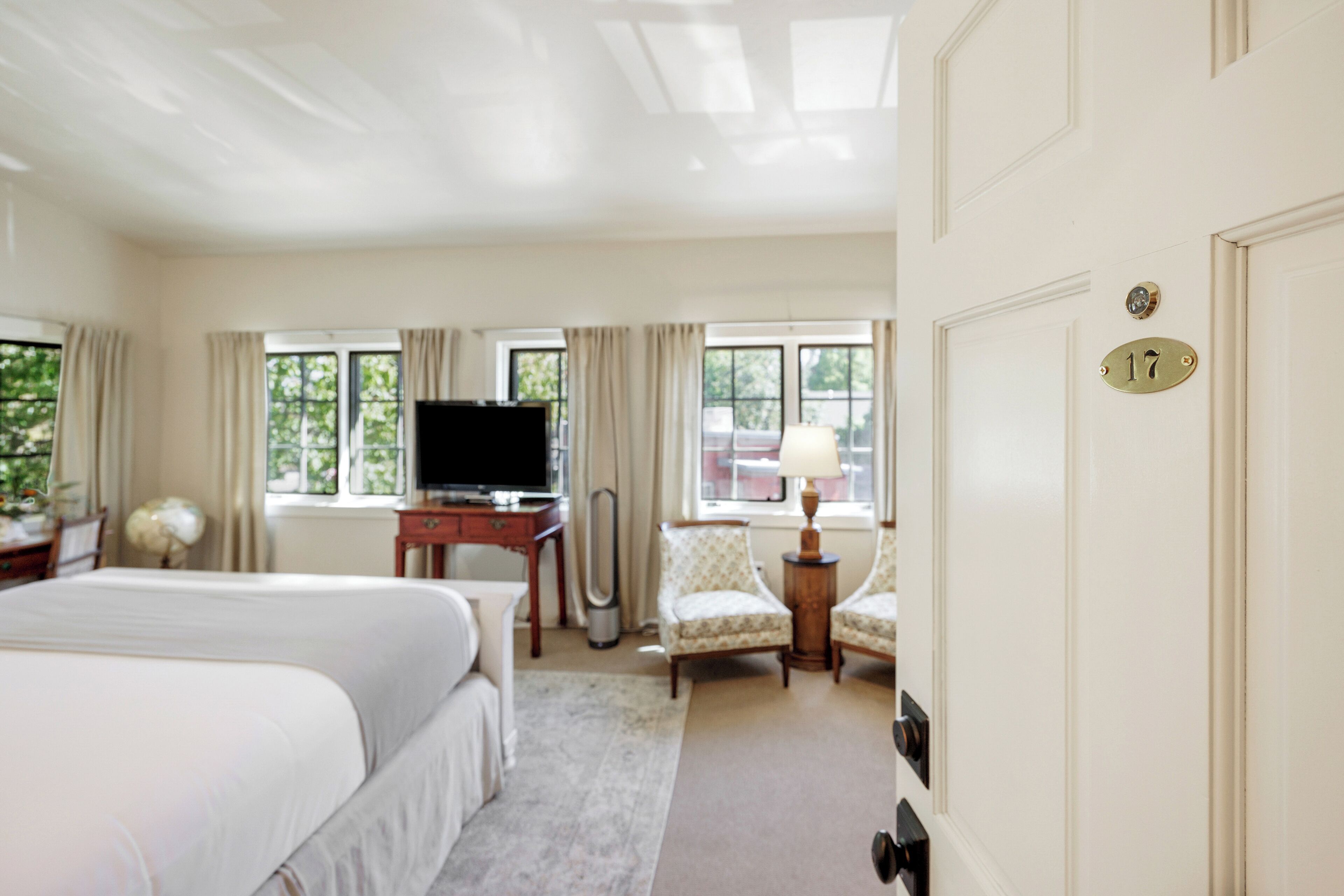 Een hotelkamer met twee bedden, een bureau met een televisie, een lamp en een stoel.