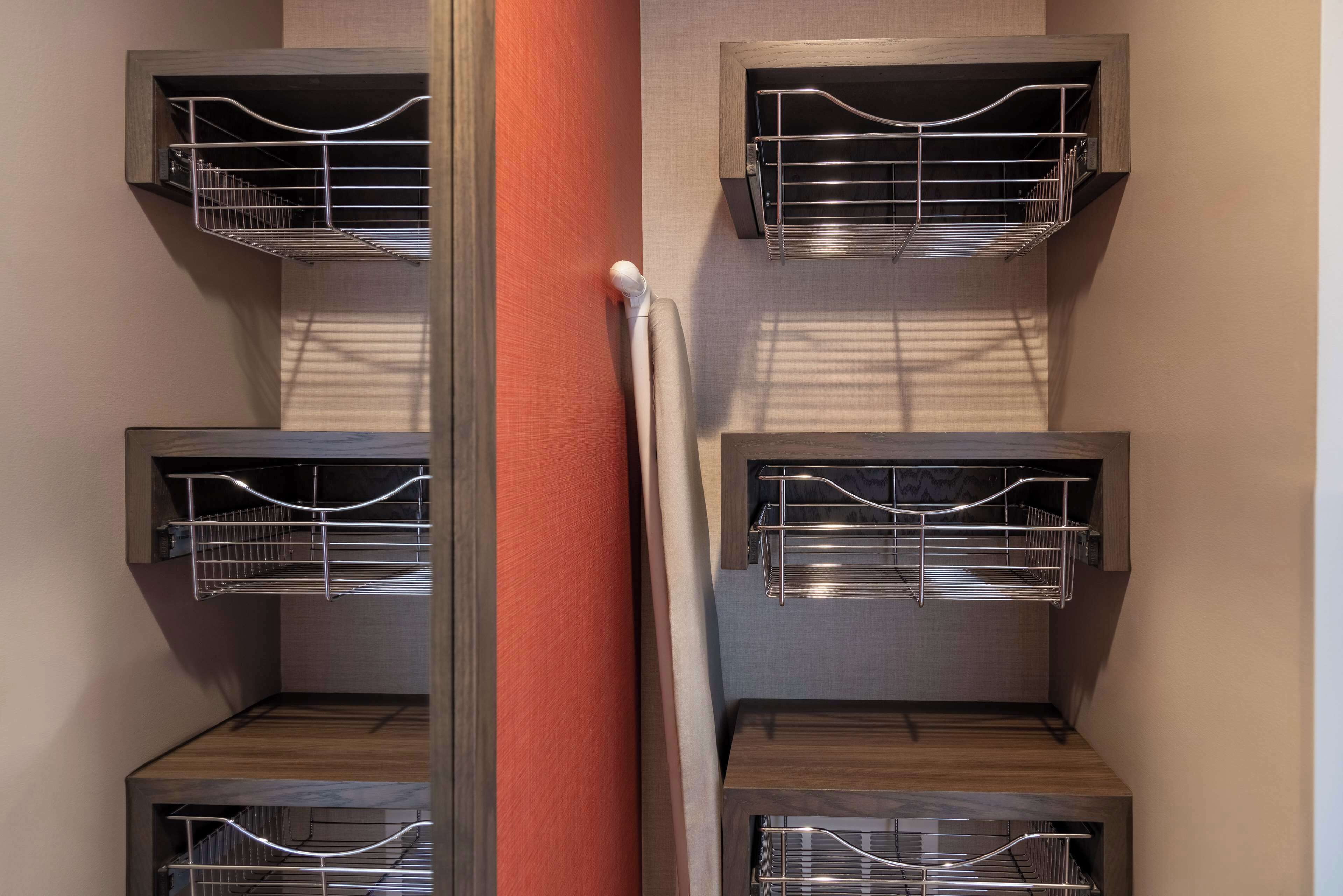 A corner of a room with a wooden cabinet and a metal rack.