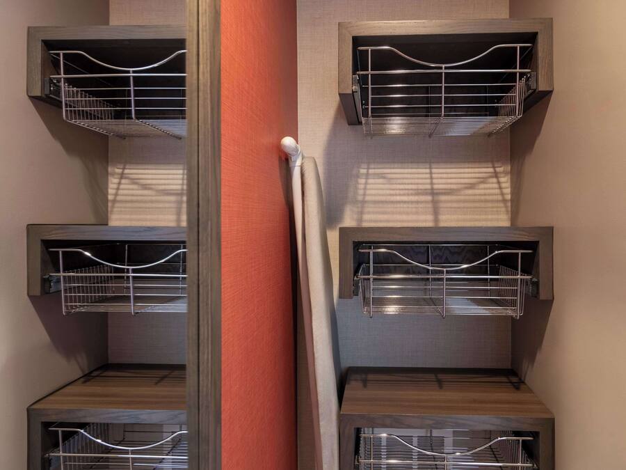 A corner of a room with a wooden cabinet and a metal rack.