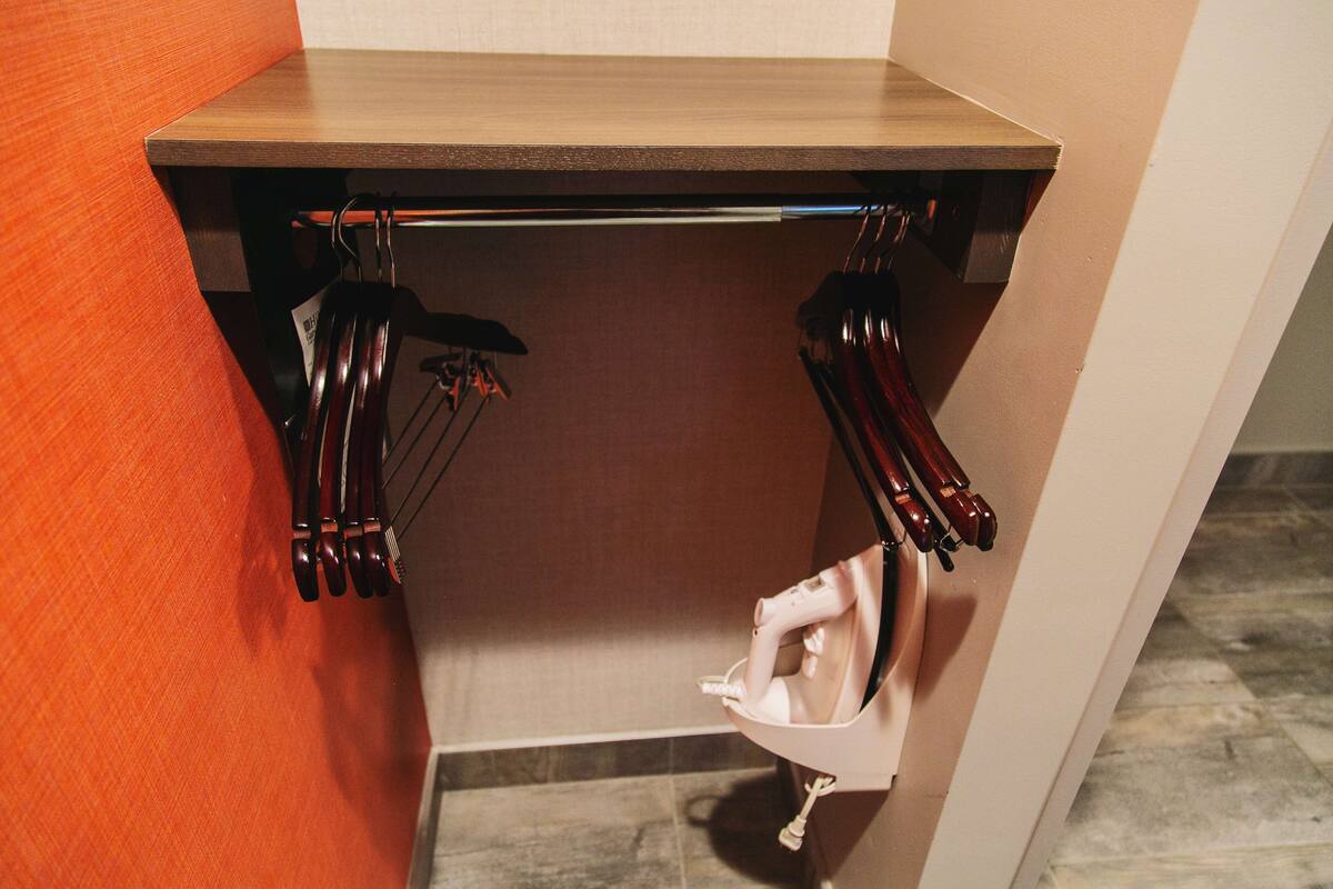 Un coin de pièce avec une table en bois et un porte-chaussures suspendu.