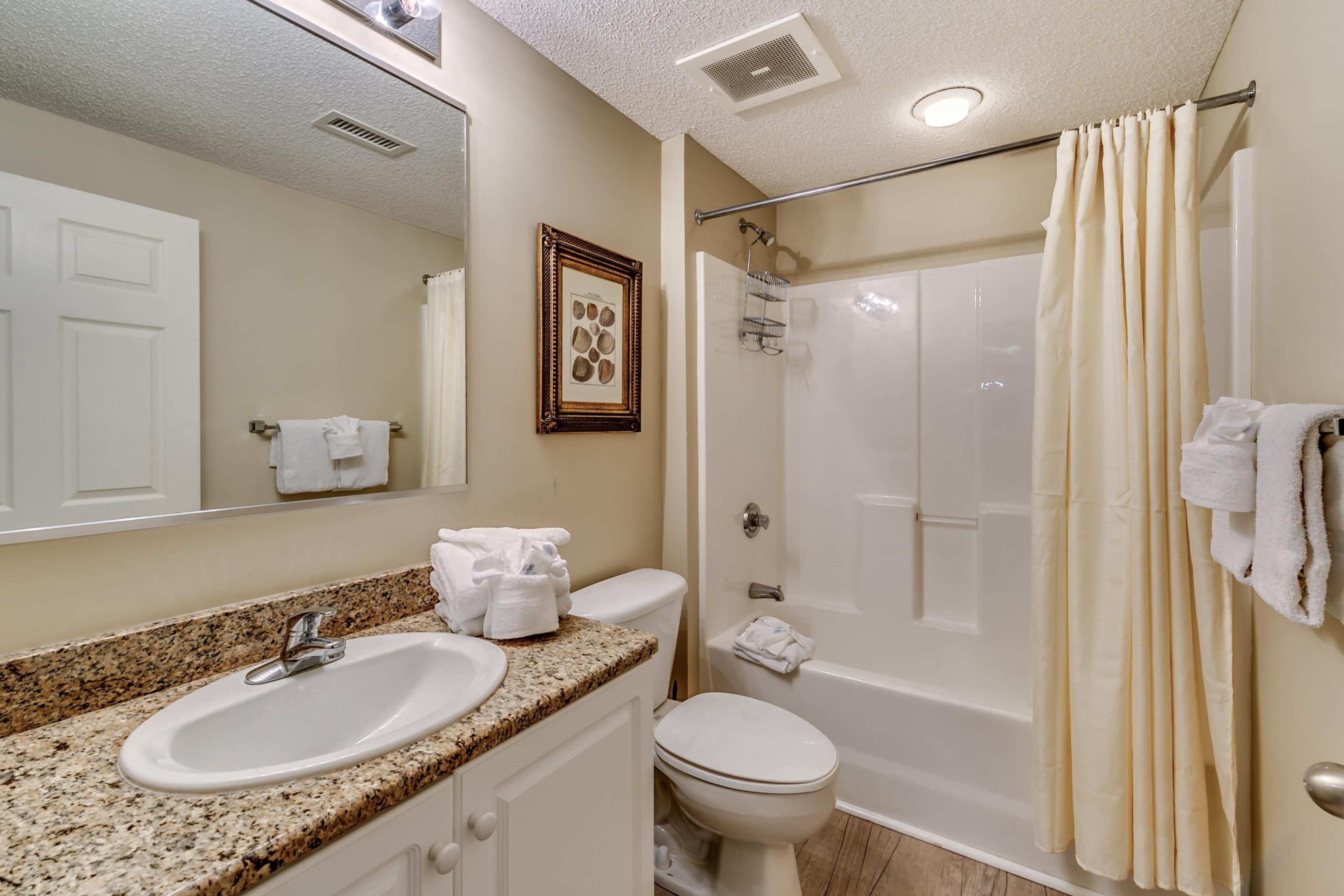 A bathroom with a sink, toilet, and shower.