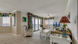 Ein Wohnzimmer mit einem weißen Sofa, einem Couchtisch und einem Fernseher.