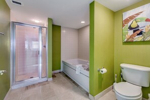 A bathroom with a glass shower enclosure, a bathtub, and a toilet. - Brighton Tower by Condo-World (Myrtle Beach)