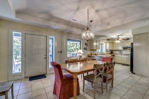 A spacious kitchen with a dining area, featuring a chandelier, wooden table, and chairs. - High C's by Condo-World (North Myrtle Beach)