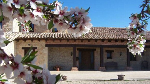 A building with a tiled roof, a stone facade, and a gravel driveway. - La Contrada (Arens de Lledo)