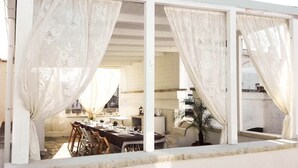 A dining area with tables set for a meal, a potted plant, and a view of the interior space. - B&B Il Borgo (Poggiardo)