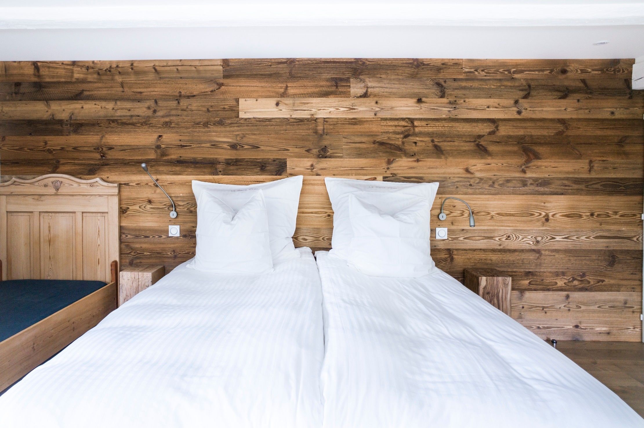 A bed with white bedding and a wooden headboard.