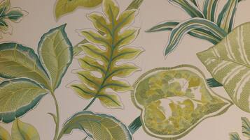 Una pared con diseño de hojas tropicales.