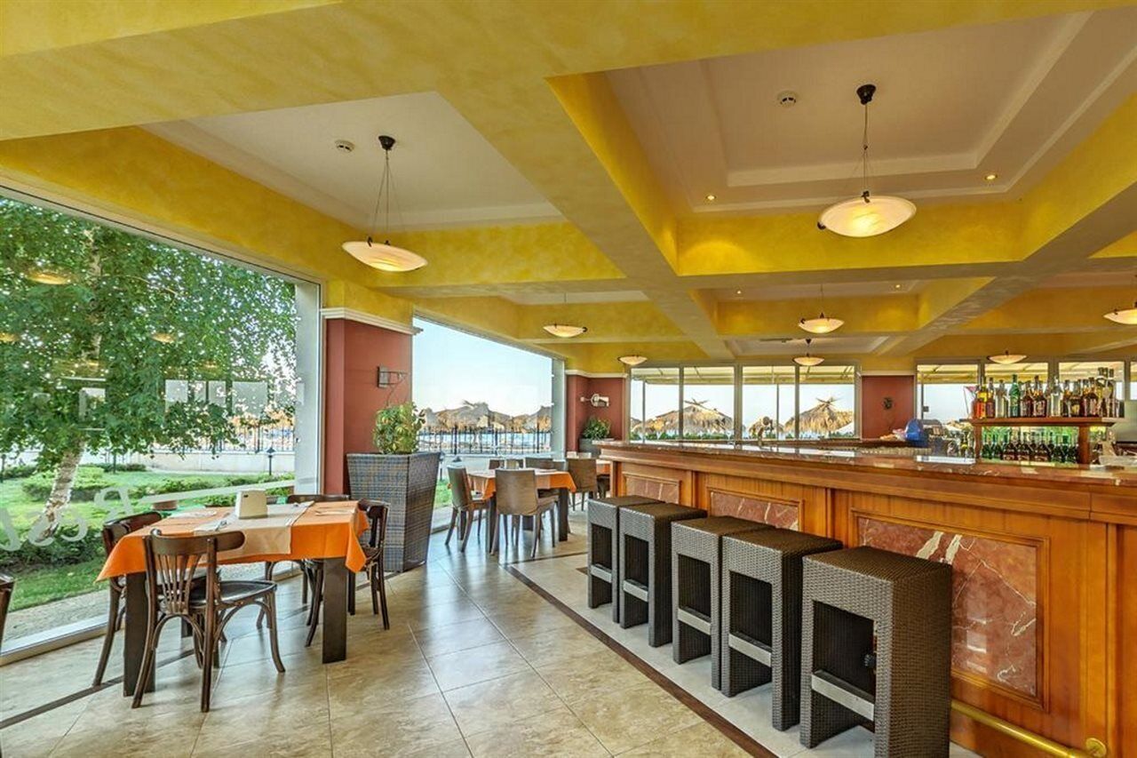 A restaurant with outdoor seating, a bar, and a view of the landscape.