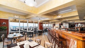 Un restaurante espacioso con techos altos, ventanas amplias y una zona de bar.
