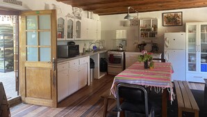 Une cuisine de taille réduite, dotée de meubles en bois, d’une cuisinière et d’un coin repas avec une table et des chaises.