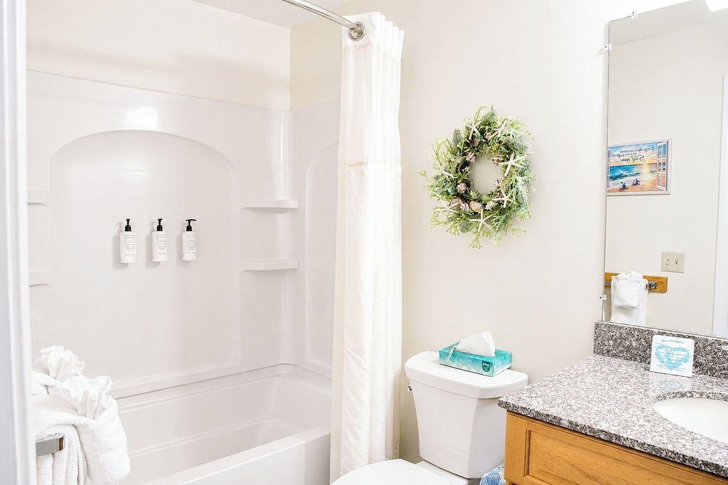A bathroom with a shower, toilet, and sink.