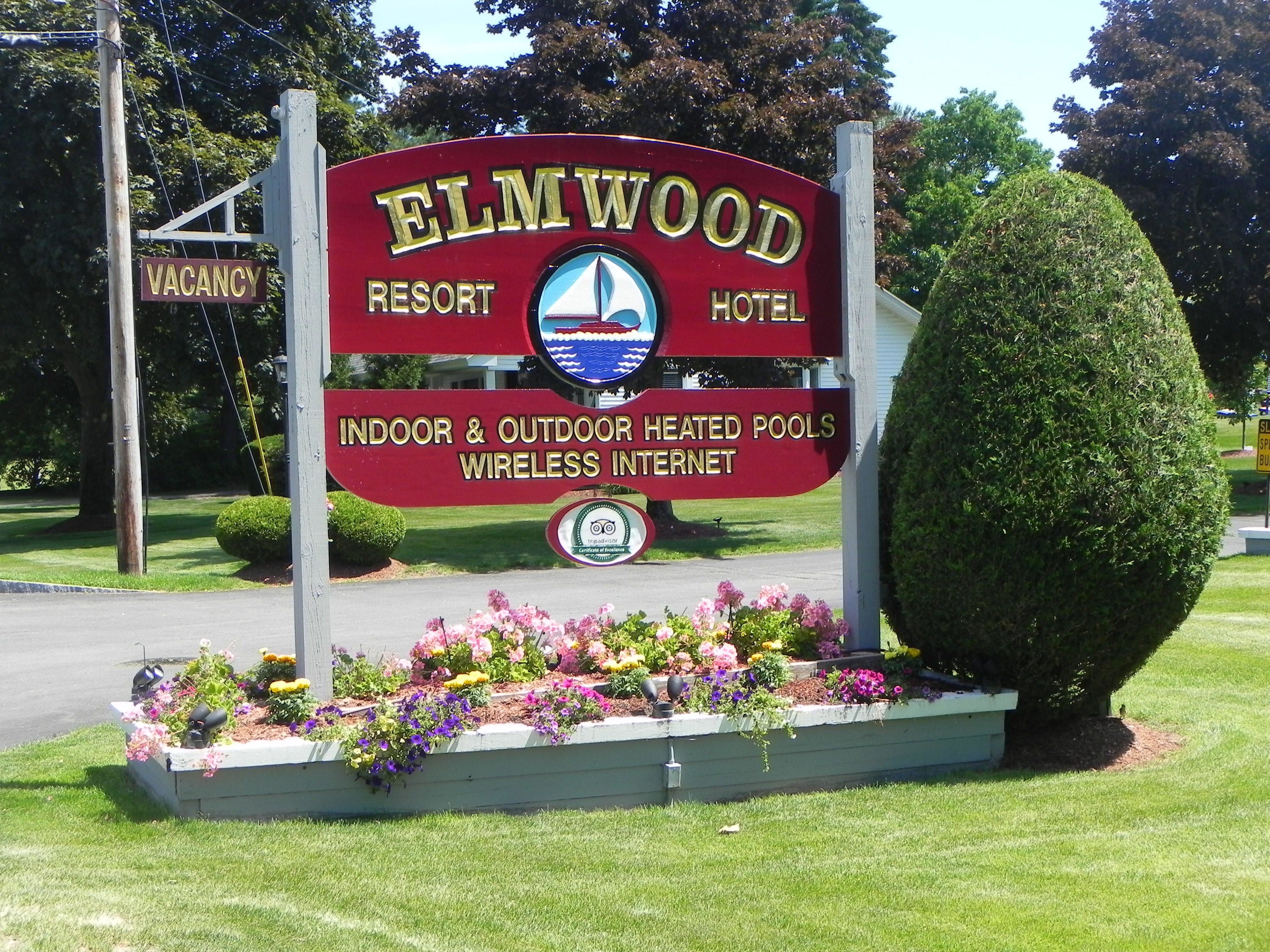 A sign for Elmwood Resort Hotel with amenities including indoor and outdoor heated pools and wireless internet.
