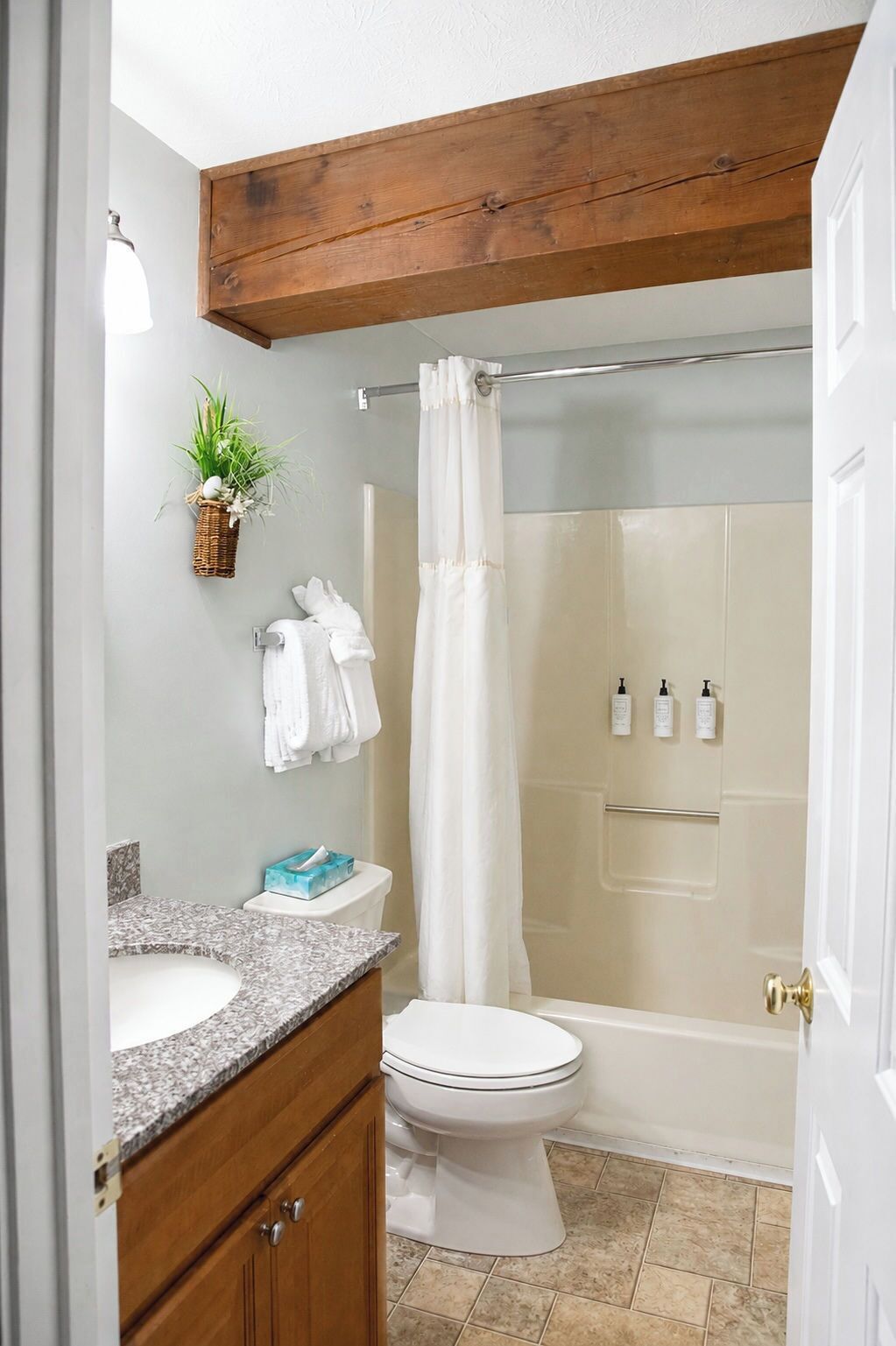 A bathroom with a shower, toilet, and sink.