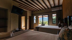 Une chambre d’hôtel avec deux lits, un téléviseur à écran plat et une grande fenêtre donnant sur les montagnes.