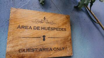 Señal de madera con la inscripción 'GUEST AREA ONLY' y 'ÁREA DE HUÉSPEDES', indicando una zona reservada para huéspedes.