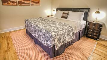 Un dormitorio ordenado con cama, mesita de noche y cómoda.