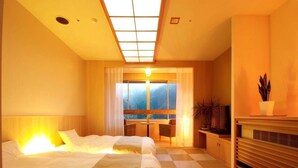 Habitación de hotel con dos camas, un escritorio, un televisor y vistas al exterior.