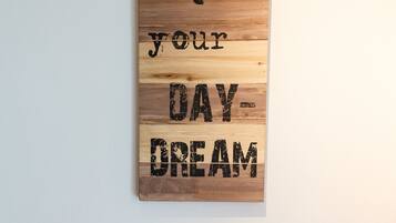 A motivational sign with the text "DON'T QUIT your DAY-DREAM" on a wooden background.