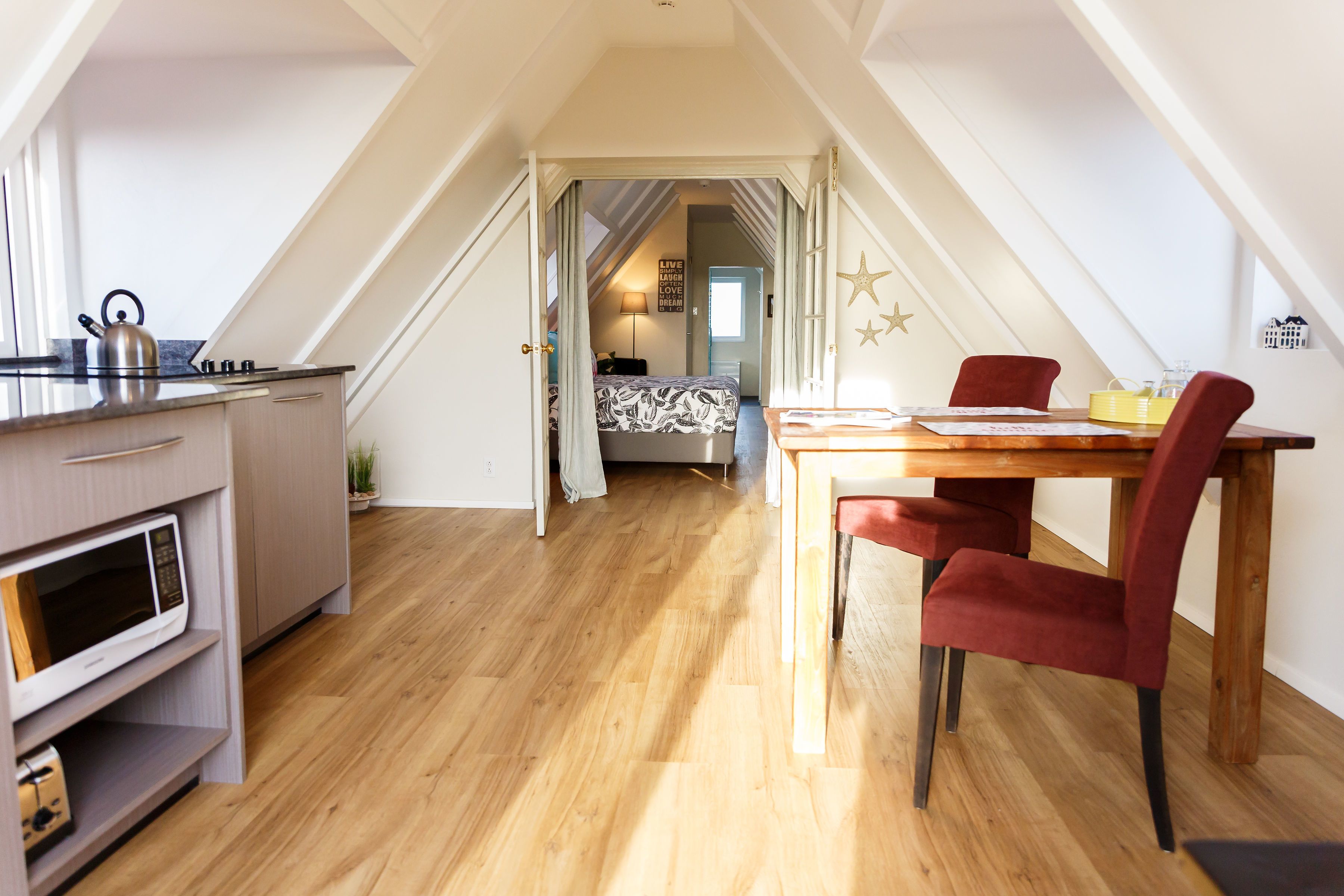 Ein modernes Loft-Schlafzimmer mit einem großen Bett, einem Schreibtisch und einem Essbereich.