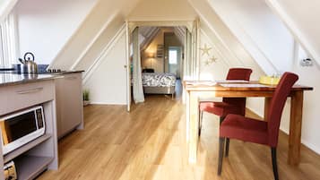 Un dormitorio estilo loft moderno con una cama grande, un escritorio y un comedor.