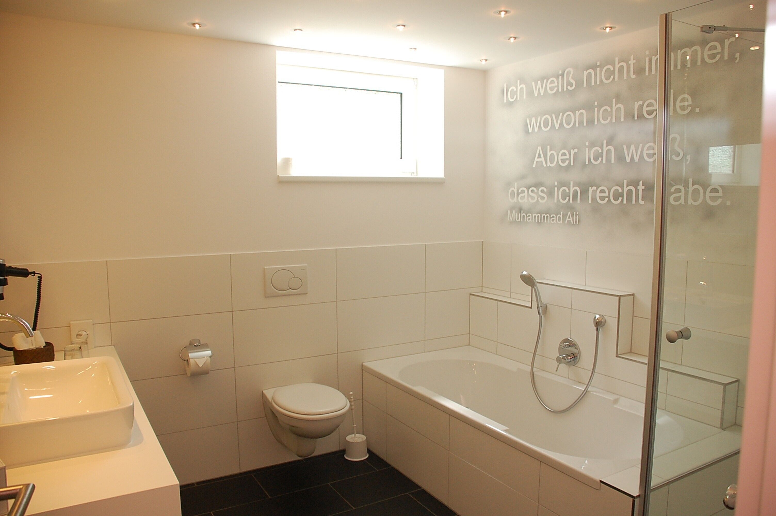Un baño moderno con bañera, inodoro y lavamanos.