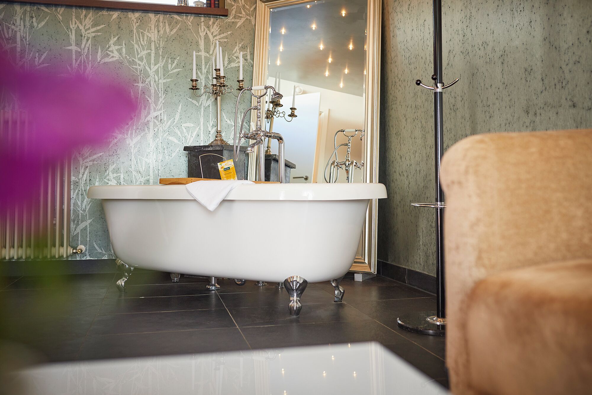 A bathroom with a freestanding bathtub, a towel, and a shower area.