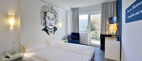 A hotel room with two beds, a desk, a chair, a TV, and a large wall art piece.