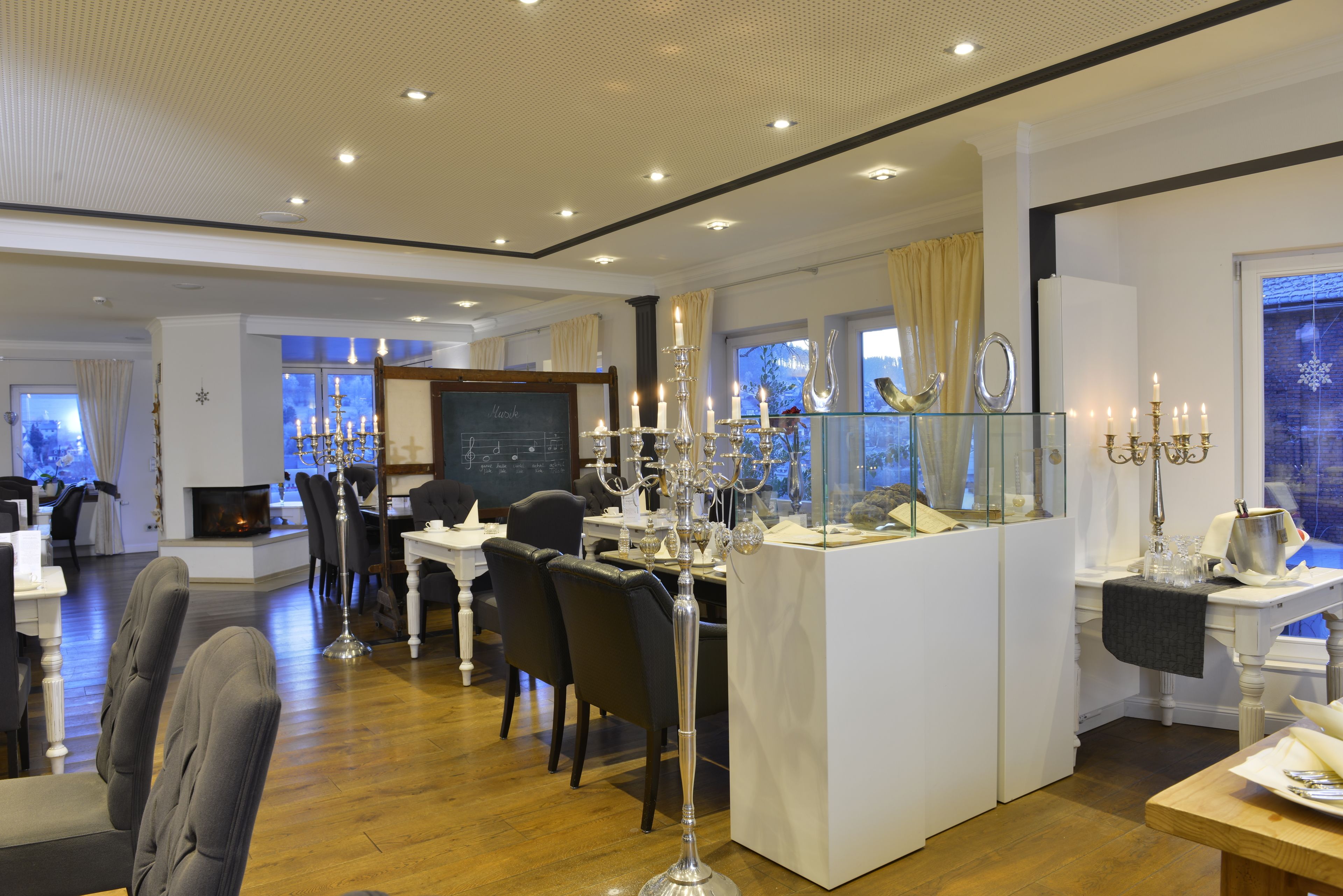A dining area with a high table, chairs, and a candelabra.
