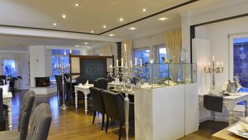 A dining area with a high table, chairs, and a candelabra.