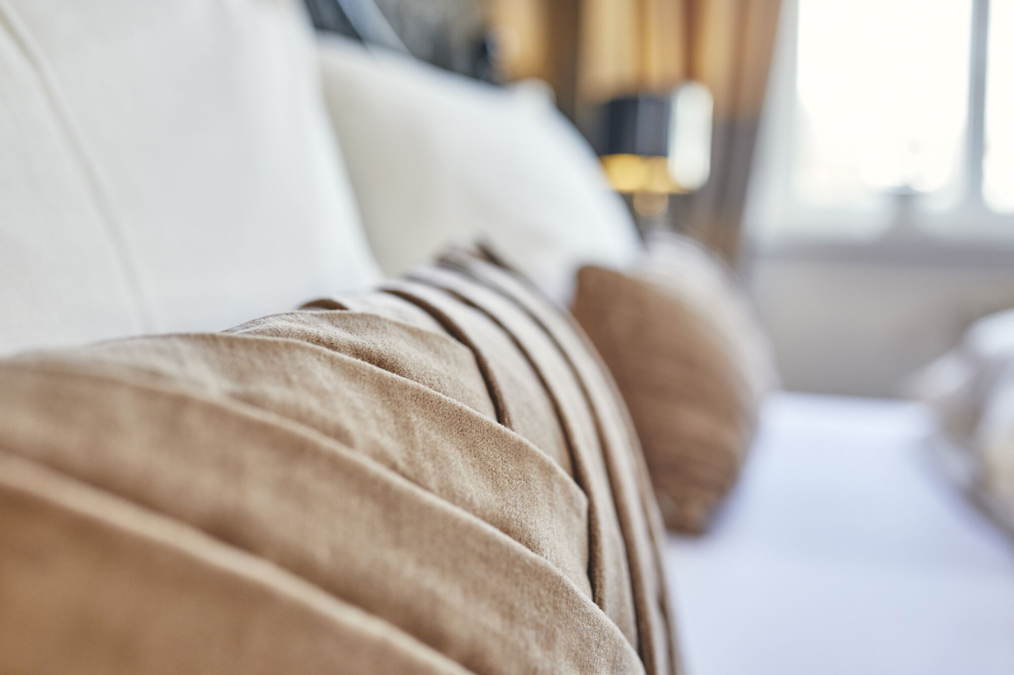 A close-up of a sofa with a textured fabric and a cushion.
