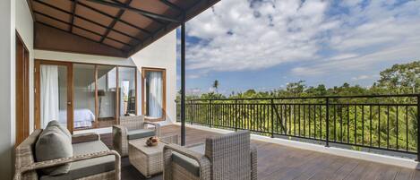 A balcony with wicker furniture, a view of the landscape, and a covered area with a ceiling structure.