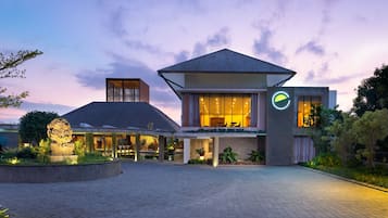 Ein modernes Hotel mit großzügigem Eingangsbereich, einem gut sichtbaren Logo und einer hell erleuchteten Fassade.