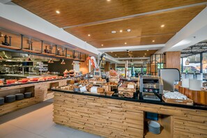Una barra de desayuno moderna con diversas opciones de comida y una máquina de café.