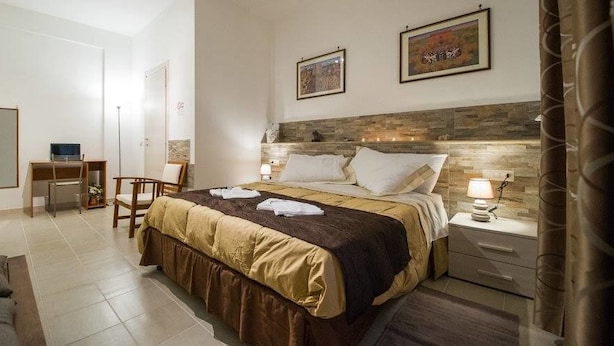 A hotel room with a bed, bedside tables, a desk, and a chair. - Vebis Guesthouse (Rome)