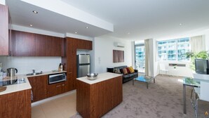A modern apartment with a kitchen, living area, and balcony.