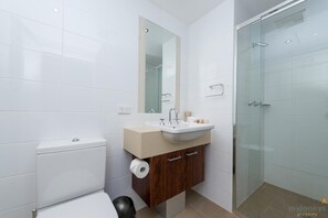 Un baño moderno con inodoro, lavabo y ducha.