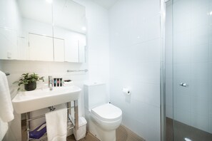 A modern bathroom with a white sink, mirror, and toilet. - Accommodate Canberra - Mode (Braddon)