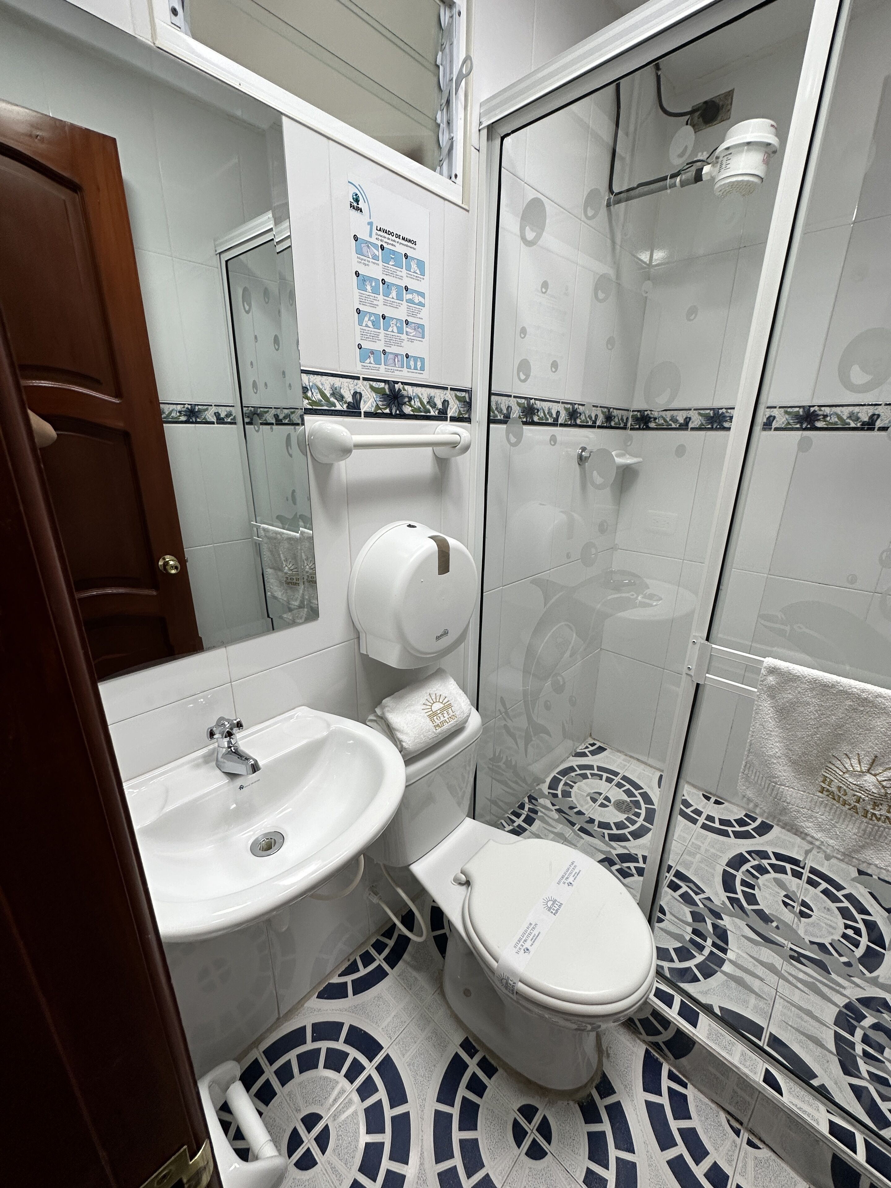 A bathroom with a toilet, sink, and shower.