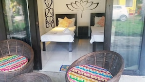 A room with two beds, a decorative wall, and wicker furniture. - Peace & Love Beach Club (Roxas)