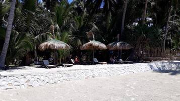 Praia particular, espreguiçadeiras, guarda-sóis, toalhas de praia