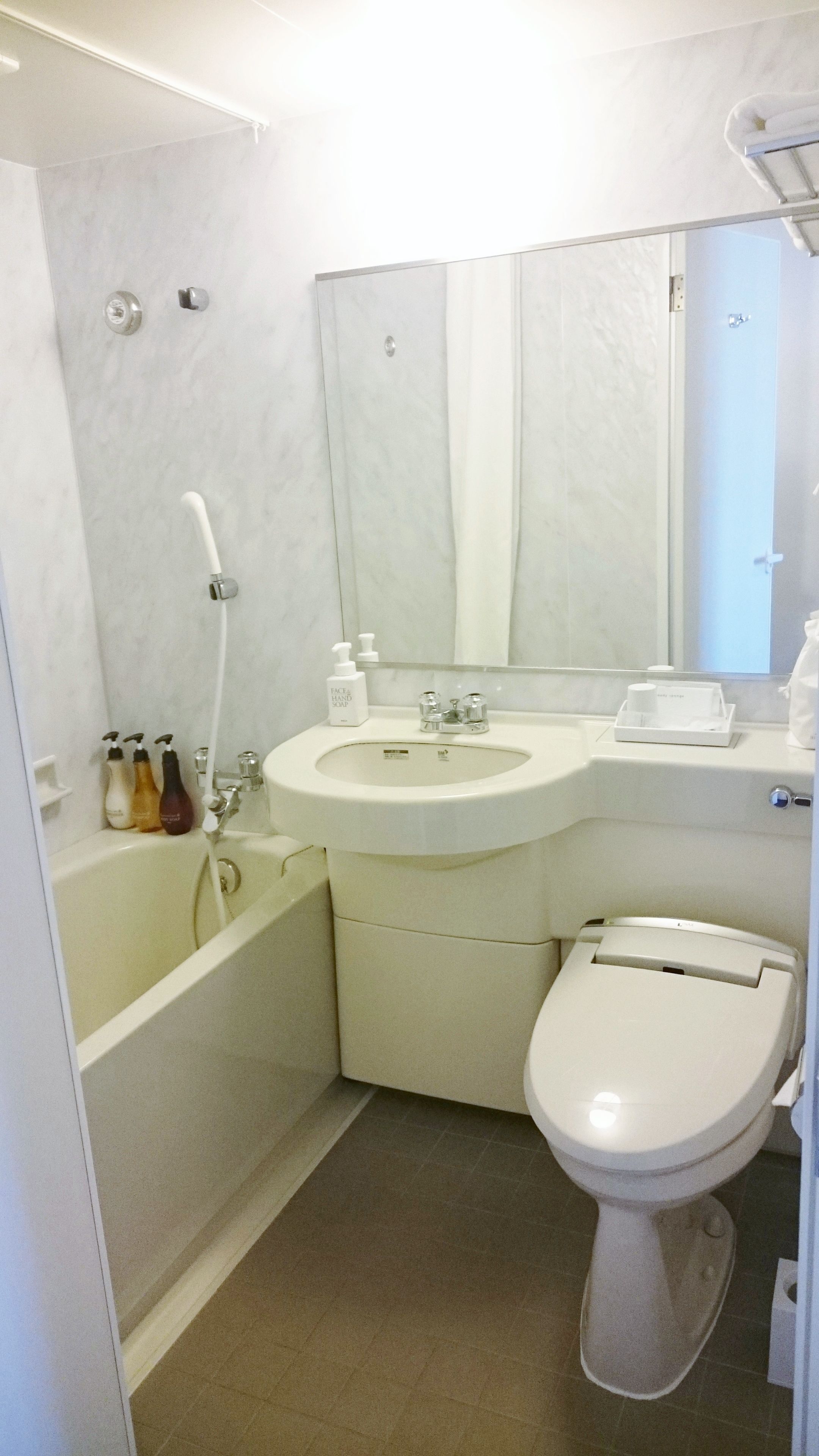 A bathroom with a sink, mirror, toilet, and bathtub.