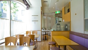 A restaurant with wooden tables and chairs, a counter, and a booth area. - Hotel South Garden Hamamatsu (Hamamatsu)