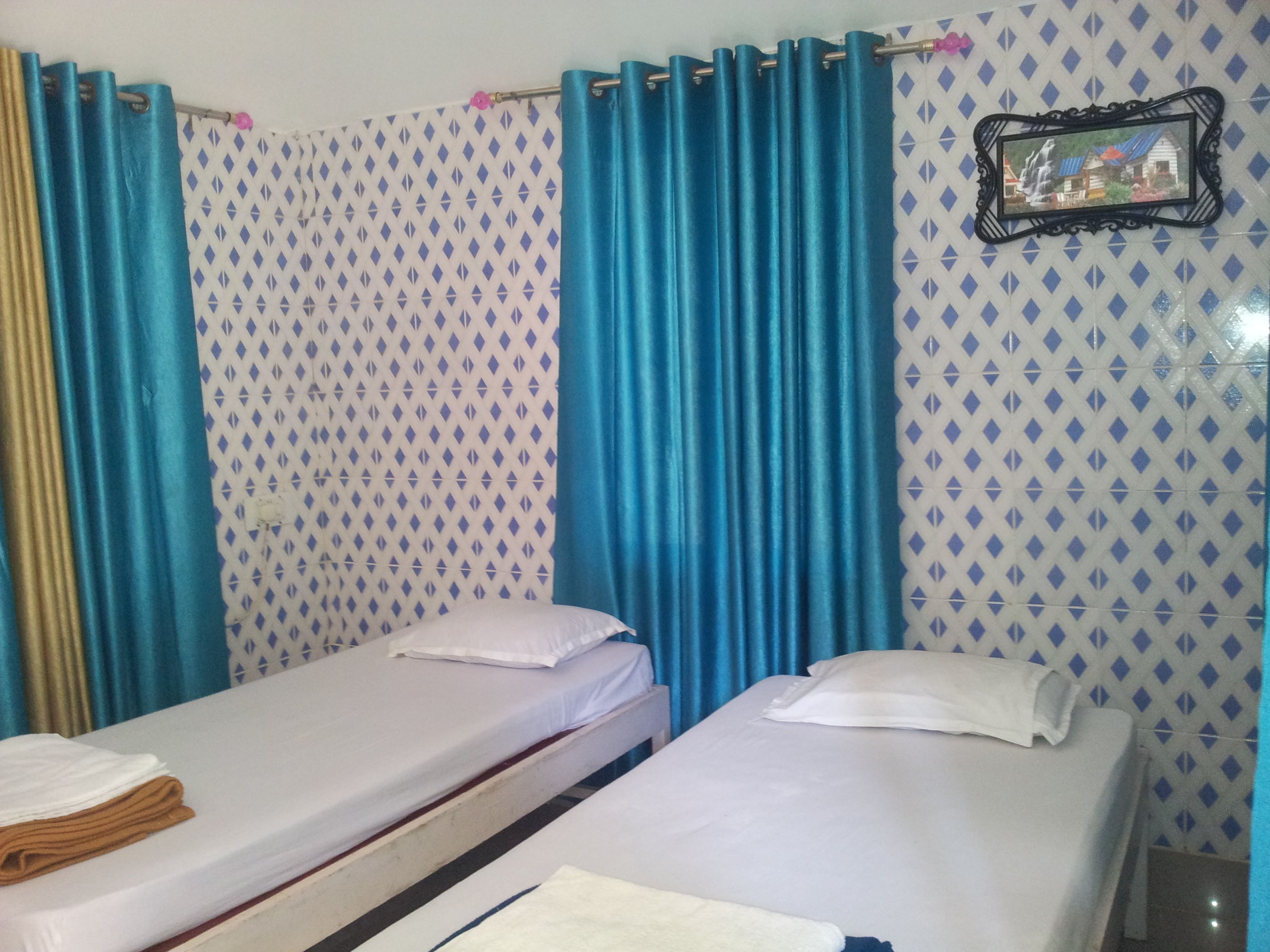 A room with two single beds, a patterned wall, and a framed picture on the wall.