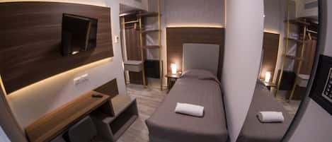 Single Room, 1 single bed, private bath | Duntäcken, minibar, värdeförvaringsskåp på rummet och skrivbord