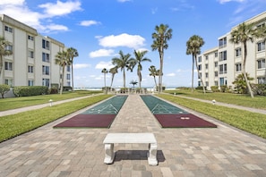 Relax in our serene courtyard, where shuffleboard courts and lush greenery create a peaceful atmosphere.